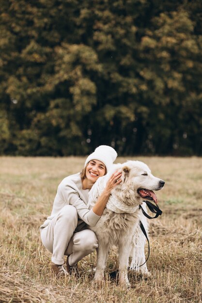 Mulher bonita, passeando com seu cachorro em um campo