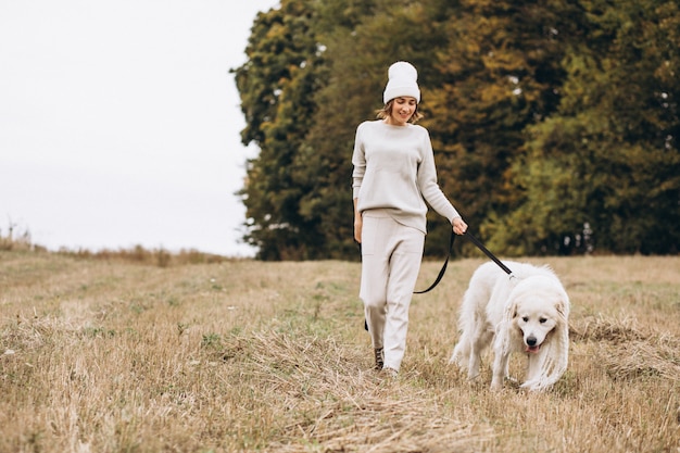 Mulher bonita, passeando com seu cachorro em um campo