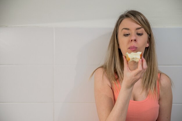 Mulher bonita que come saudável e sorridente. A mulher nova e charmosa maquiagem feminina de cabelos compridos mantém grande maçã vermelha. Alimentação saudável, alimentação vegetariana, dieta e conceito de pessoas.