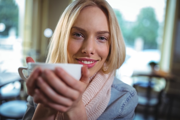 Mulher bonita que tem uma chávena de café no cafÃ ©