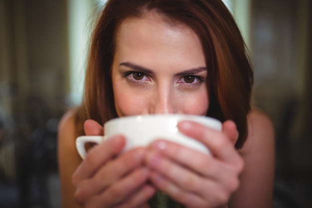 Mulher bonita que tem uma chávena de café no cafÃ ©