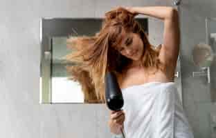 Foto grátis mulher bonita secando o cabelo no banheiro