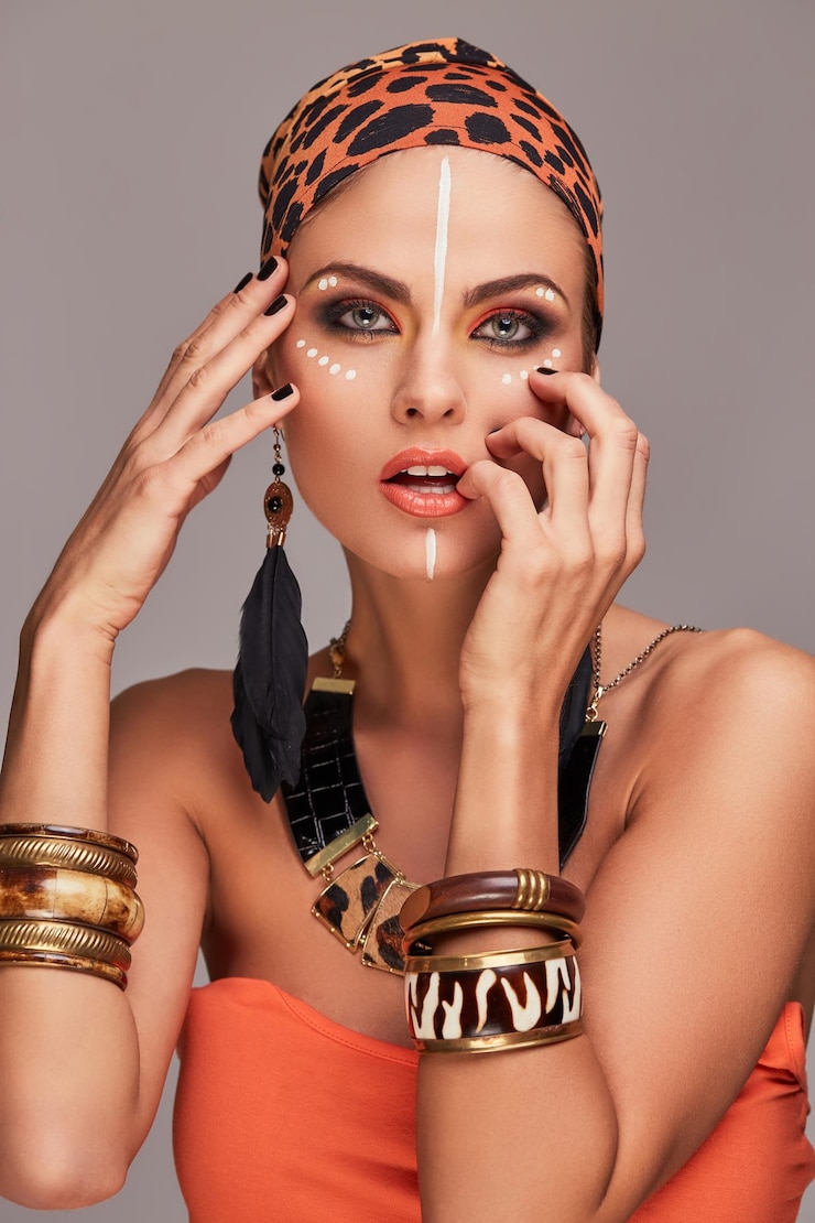 Foto grátis mulher bonita sedutora usando xale colorido na cabeça e acessórios, posando com a mão no rosto e lábios. isolado em fundo cinza.