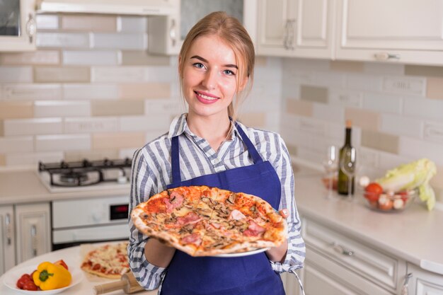 Mulher bonita segurando pizza cozida nas mãos