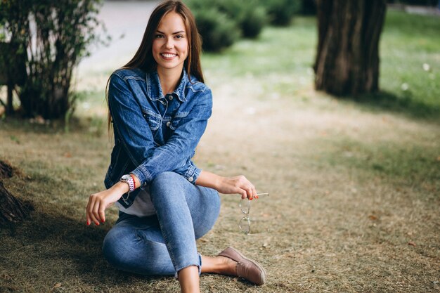 Mulher bonita sentada ander uma árvore