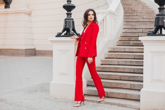 Mulher bonita sexy estilo rico de negócios em um terno vermelho andando na rua da cidade, tendência da moda primavera verão