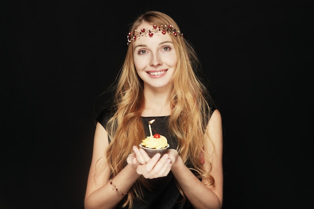 Mulher bonita sorridente segurando o bolo de aniversário