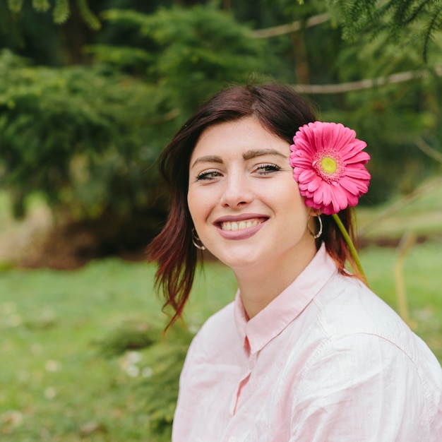 Mulher bonita sorrindo com flor no cabelo