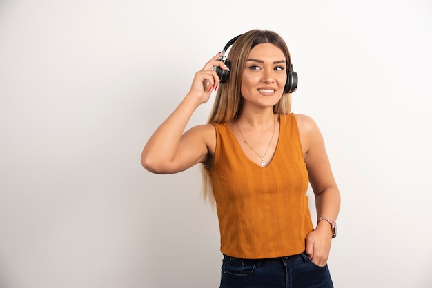 Foto grátis mulher bonita usando fones de ouvido em fundo branco.