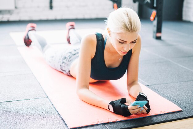 Mulher bonita usando o smartphone na academia