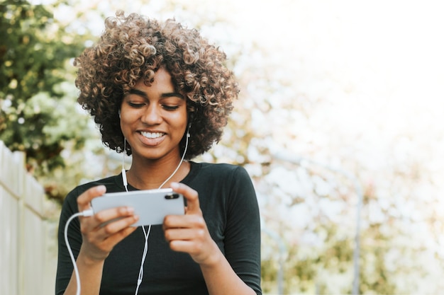 Foto grátis mulher bonita usando smartphone na mídia remixada do jardim