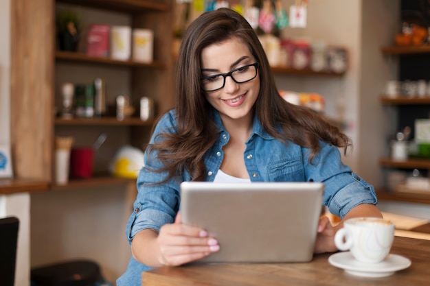 Foto grátis mulher bonita usando tablet digital no café