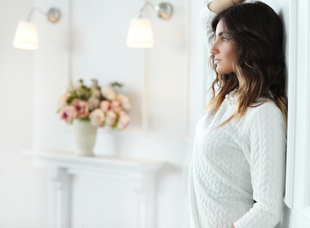 Foto grátis mulher bonita usando vestido branco no quarto branco