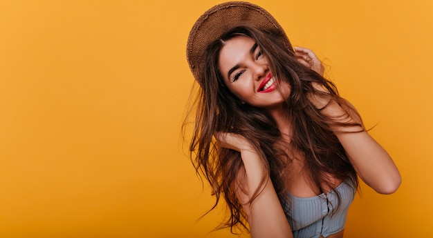 Mulher branca despreocupada com um penteado moderno rindo depois da sessão de fotos com roupa de verão