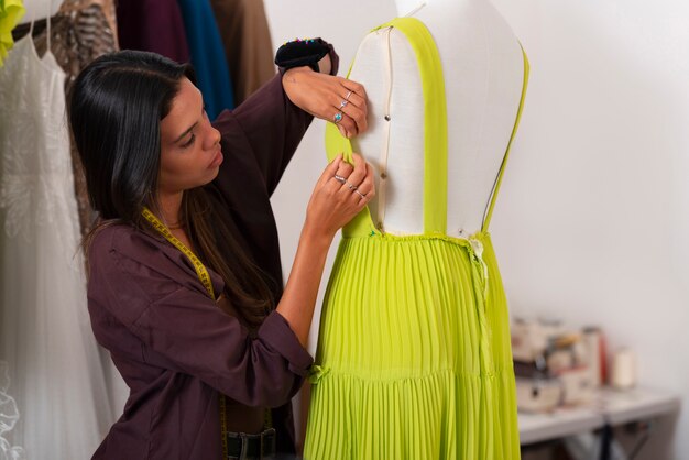 Mulher brasileira de tom médio trabalhando como designer de roupas