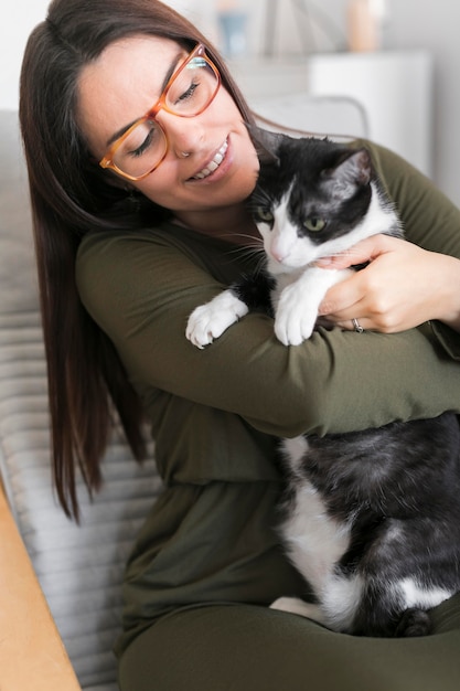 Mulher brincando com gato sentado na cadeira