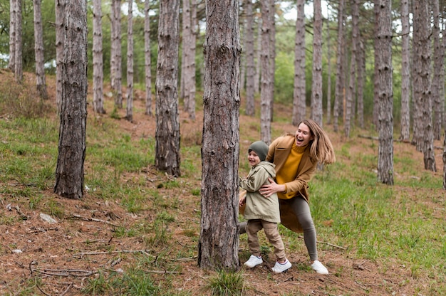 Mulher brincando com seu filho na floresta