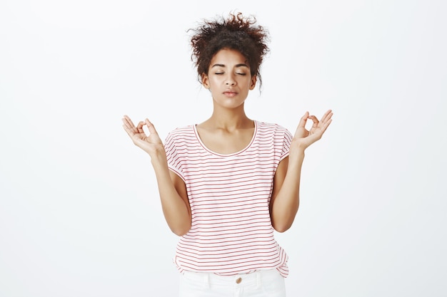 Foto grátis mulher calma e relaxada com um penteado afro posando no estúdio