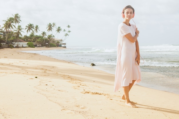 Mulher caminhando na areia da praia