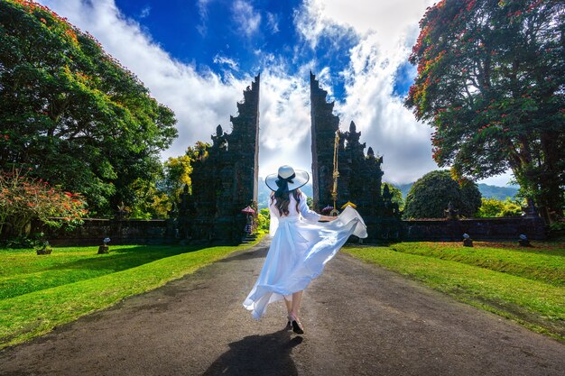 Mulher caminhando no grande portão de entrada, Bali, na Indonésia