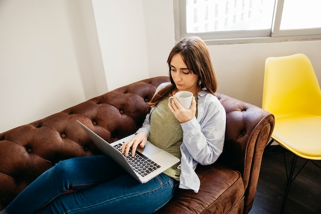 Mulher casual relaxante com laptop