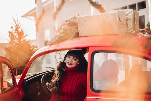 Mulher caucasiana alegre sentada no banco do motorista do carro sorrindo
