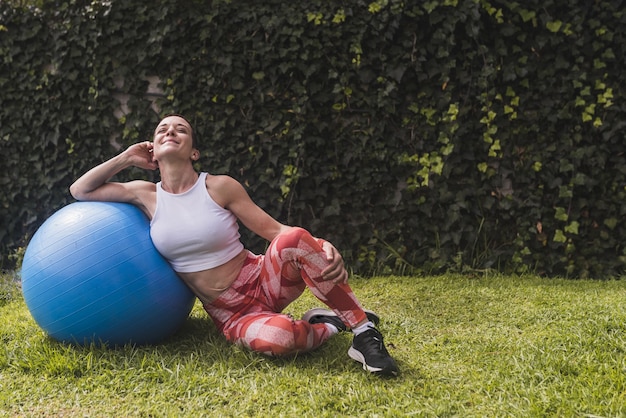 Mulher caucasiana, atlética, realizando exercícios de musculação no parque