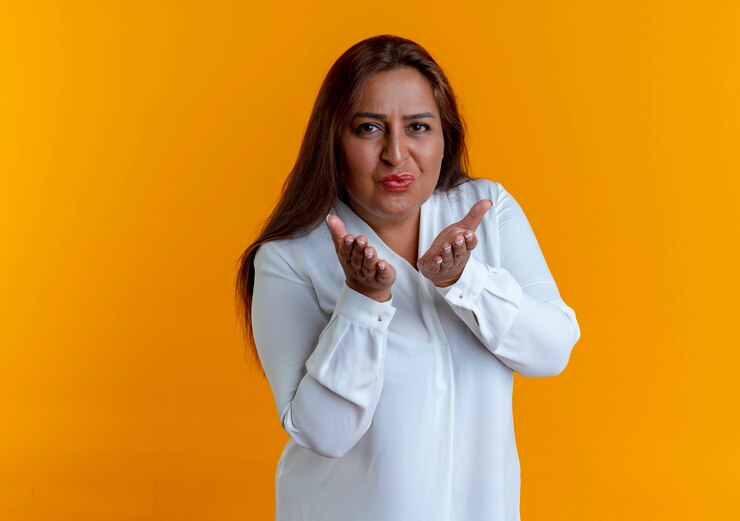Foto grátis mulher caucasiana de meia-idade satisfeita e casual mostrando um gesto de beijo
