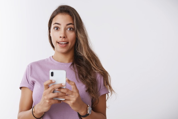 Mulher caucasiana divertida usando smartphone