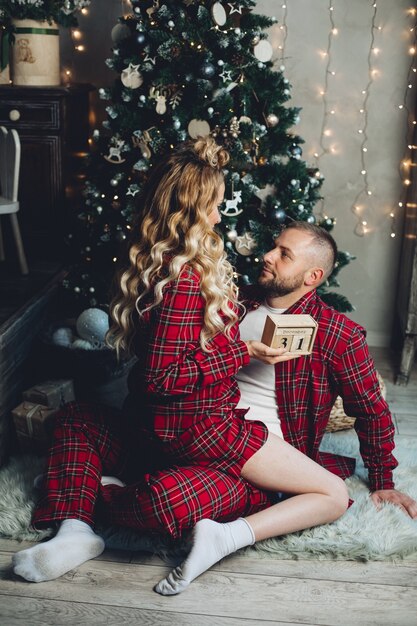 Mulher caucasiana e seu marido relaxa na sala de estar em uma atmosfera de Natal juntos.