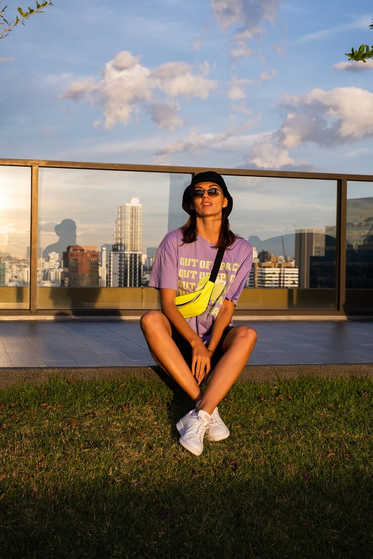 Foto grátis mulher caucasiana elegante no panamá da moda e bolsa de néon na cintura no telhado em bangkok com vista