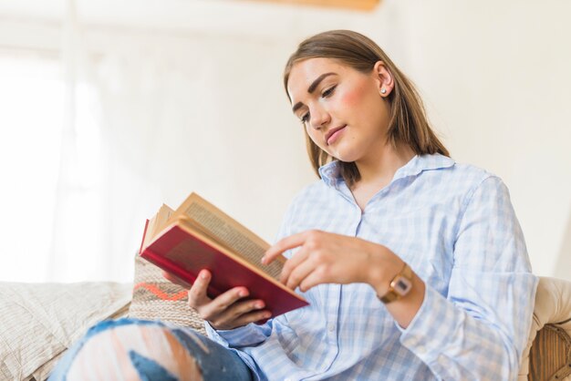 Mulher caucasiana, lendo o livro em casa