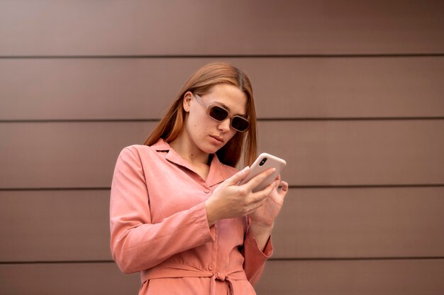 Mulher caucasiana mandando mensagem de texto para alguém em seu smartphone
