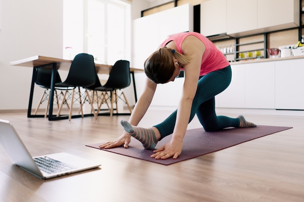 Mulher caucasiana, praticando ioga em casa