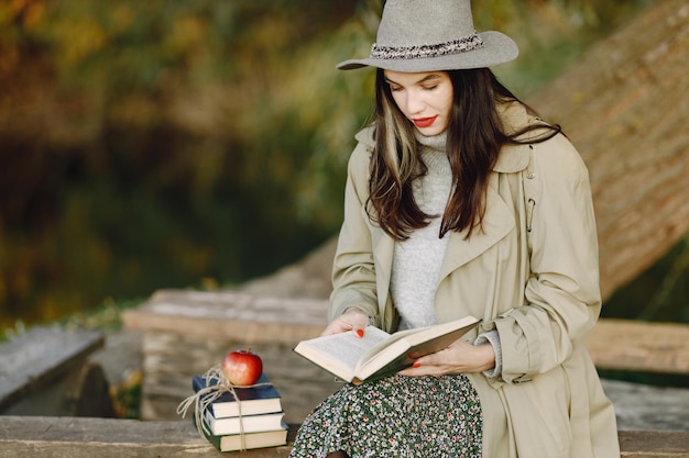 Mulher caucasiana sentada em um banco de madeira com livros