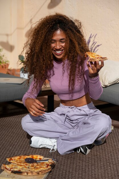 Mulher cheia a comer uma pizza deliciosa.