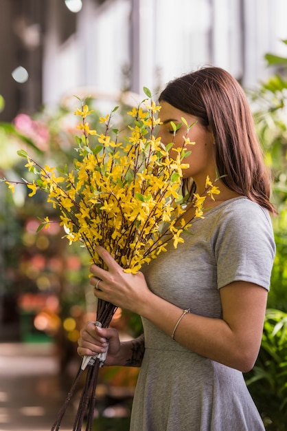 Mulher, cheirando, amarelo, flores