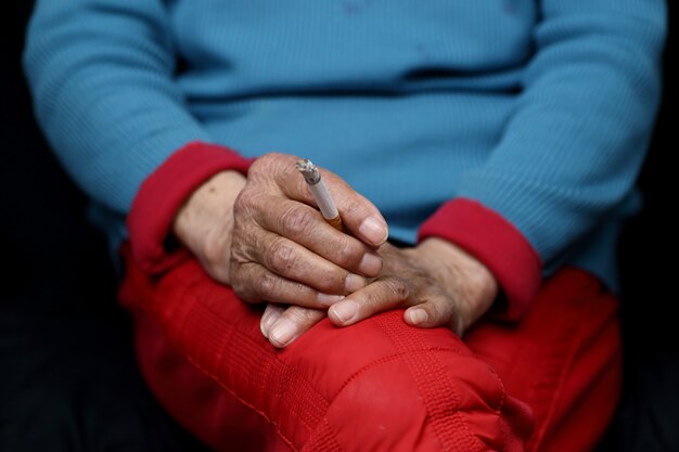 Mulher chinesa idosa sentada e fumando - conceito de empoderamento das mulheres