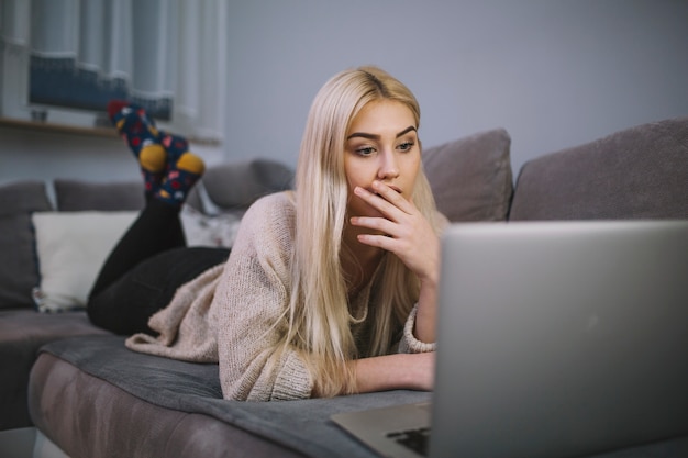 Foto grátis mulher chocada usando o laptop no sofá