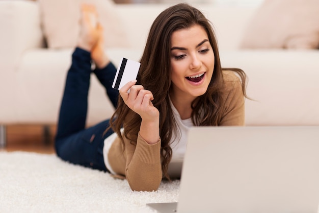 Foto grátis mulher chocante com laptop e cartão de crédito em casa