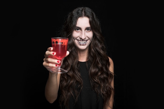 Mulher cinza mostrando o vidro com líquido vermelho