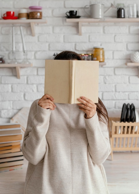 Foto grátis mulher cobrindo o rosto com um livro