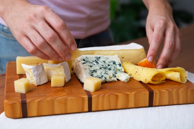 Mulher colocando queijos azuis, macios ou duros