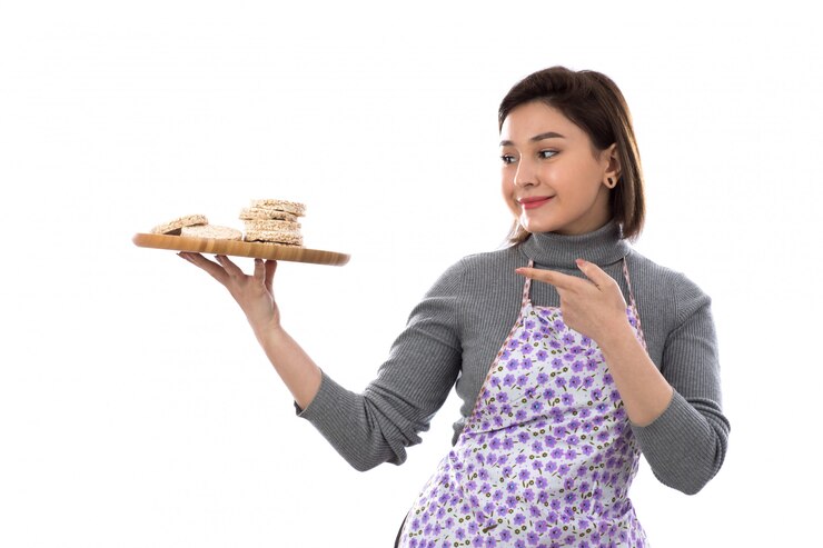 Foto grátis mulher com avental roxo segurando cookies