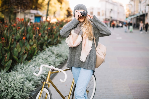 Mulher com bicicleta tirando fotos