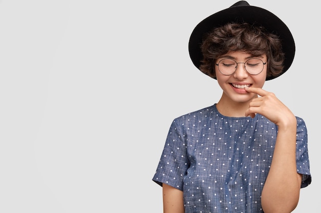 Mulher com blusa de bolinhas e chapéu grande