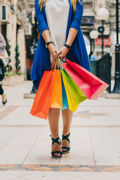 Mulher com bolsas coloridas na rua