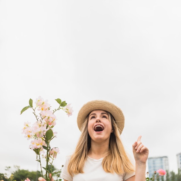 Mulher com buquê de flores, apontando o dedo para cima