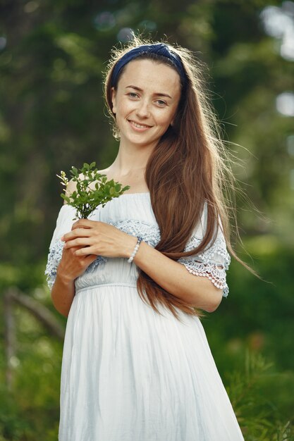 Mulher com cabelo comprido. Senhora de vestido azul. Menina com natureza intocada.