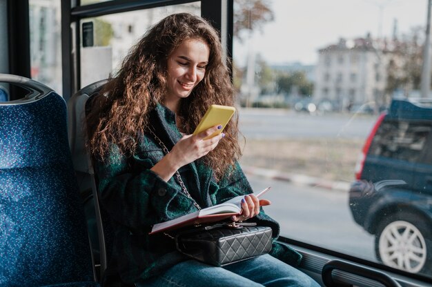 Mulher com cabelo encaracolado viajando de ônibus